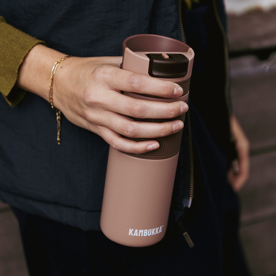 Bruine koffiebeker van Kambukka in de hand