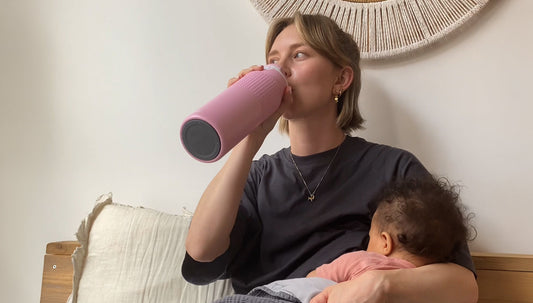 vrouw die uit een Kambukka waterfles drinkt terwijl ze borstvoeding geeft